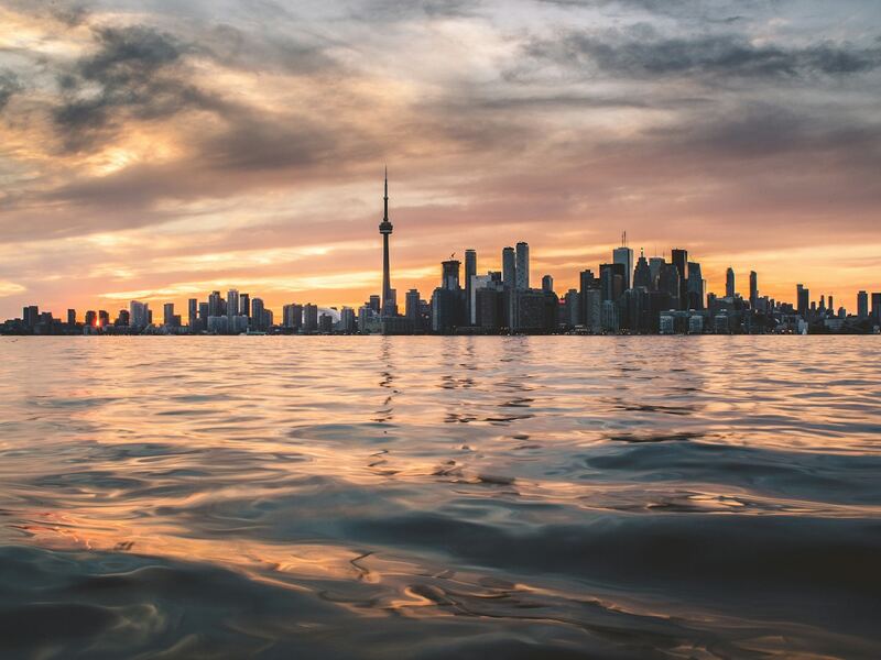 Toronto skyline and CN Tower across Lake Ontario at sunset